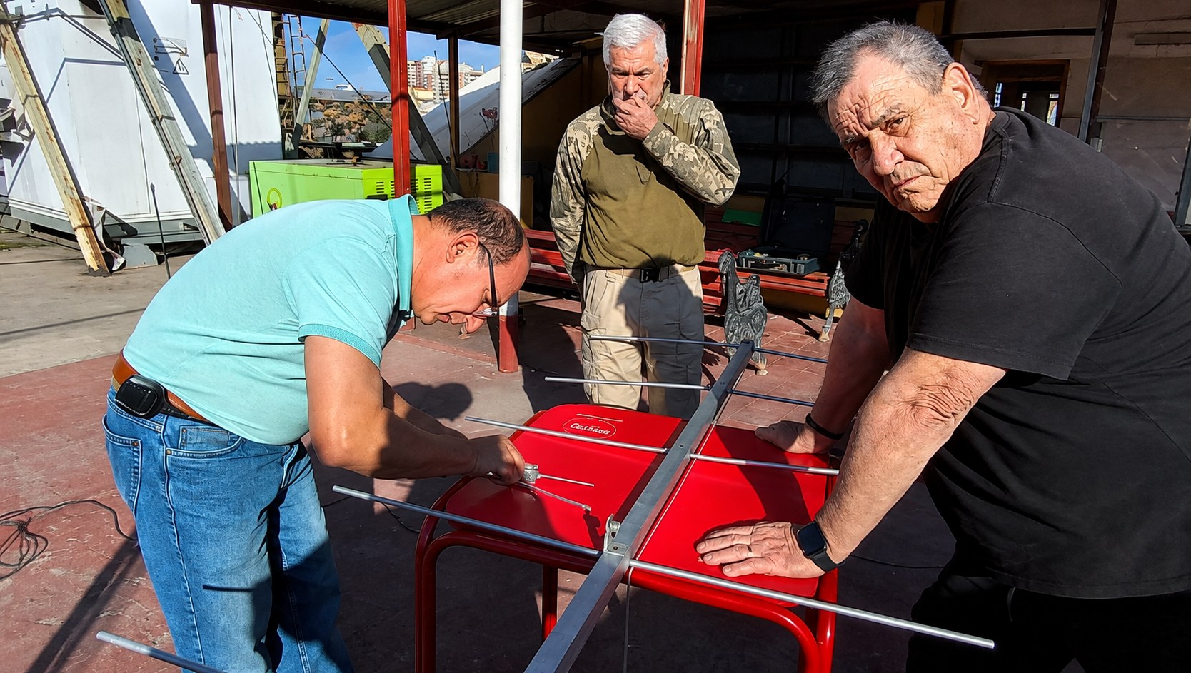 Participantes ajustando elementos de una antena sobre una mesa